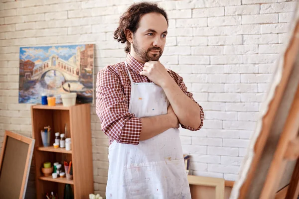 Artist looking at canvas in studio — Stock Photo, Image