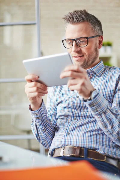 Zakenman met touchpad zitten in kantoor — Stockfoto