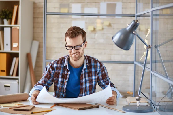 Architect looking at blueprint in office — Stock Photo, Image