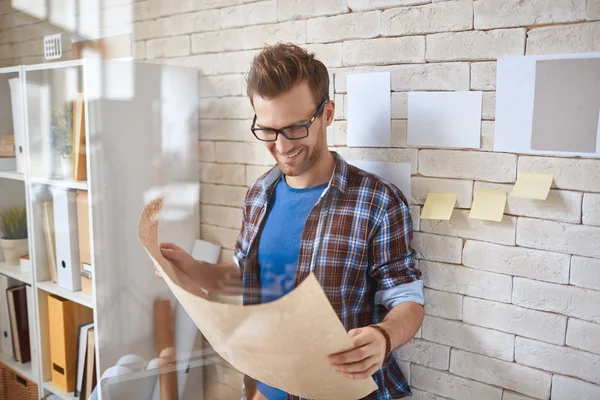 Architect bedrijf blauwdruk in office — Stockfoto