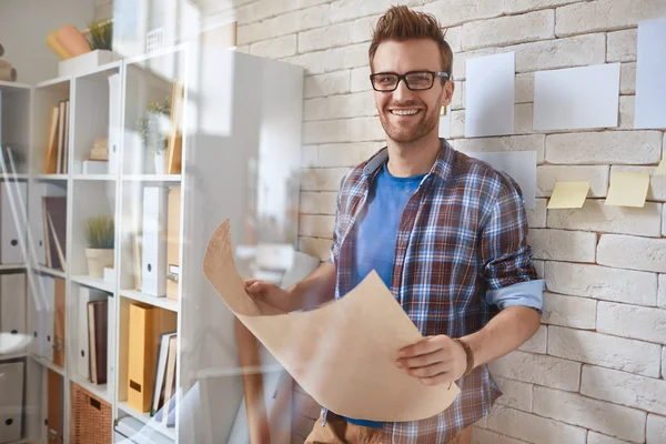 Zakenman met blauwdruk in office — Stockfoto