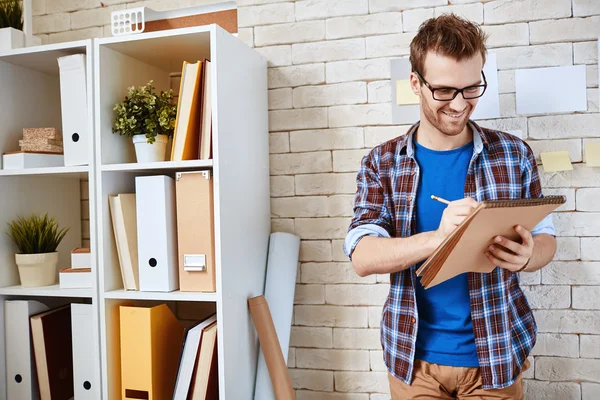 Zakenman met Kladblok in office — Stockfoto