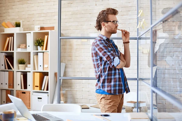 Businessman reading reminders in office — Stock Photo, Image