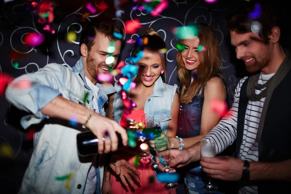 Man gieten champagne in fluiten van vrienden — Stockfoto