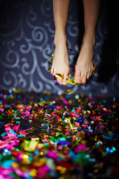 Pies en salto sobre el piso con confeti — Foto de Stock