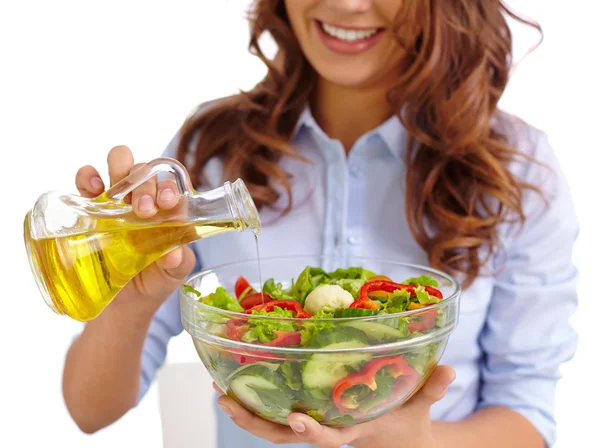 Mujer añadiendo aceite de oliva en ensalada vegetal —  Fotos de Stock