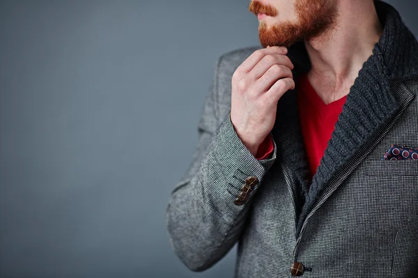 Nadenkend jongeman raken zijn baard — Stockfoto