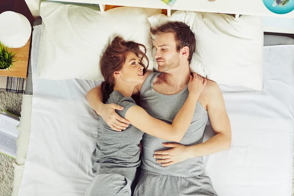 Pár objímat v posteli — Stock fotografie