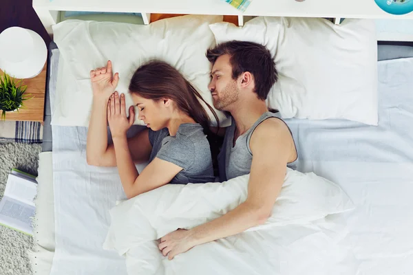 Pareja joven durmiendo en la cama — Foto de Stock