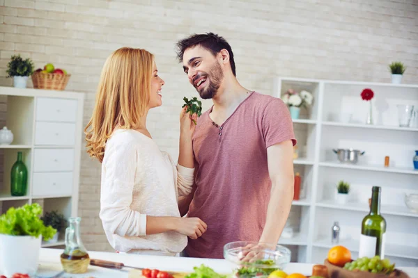 Woman giving parsley to young man — Stock Photo, Image