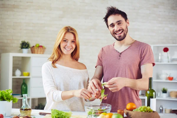 Joven pareja cocina ensalada —  Fotos de Stock