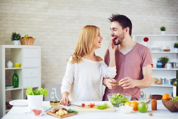 Woman giving tomato to her husband — Stock Photo, Image