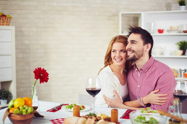 Couple embracing   by dinner table — Stock Photo, Image
