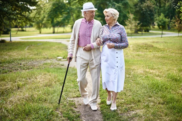 Пожилые люди прогуливаются в летнем парке — стоковое фото