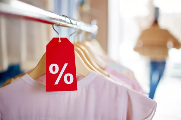 Clothes on hangers with sign of percent — Stock Photo, Image