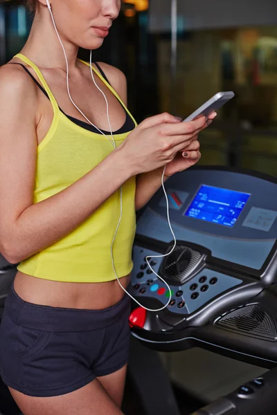 Mujer escuchando música en el gimnasio —  Fotos de Stock