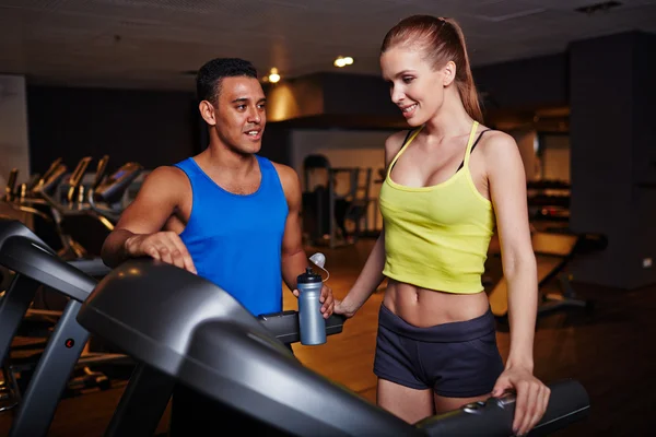 Mujer y hombre pasar tiempo en el gimnasio — Foto de Stock