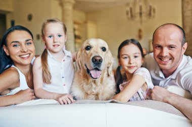 Aile üyeleri tarafından çevrili köpek