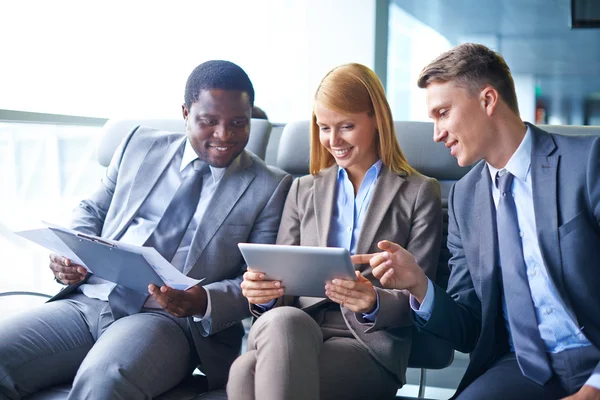 Empresarios discutiendo datos en touchpad —  Fotos de Stock