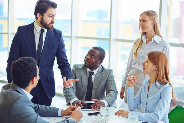 Zakenman die zijn idee aan collega's verklaart — Stockfoto