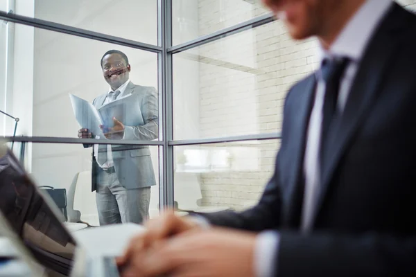 Business man looking at his working colleague — стоковое фото