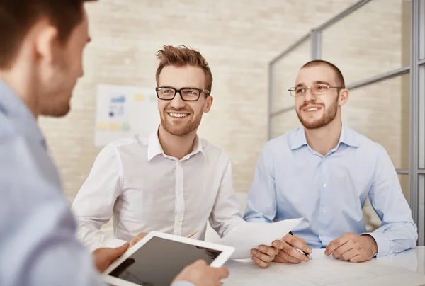 Businessmen looking at colleague  at meeting — Stock Photo, Image