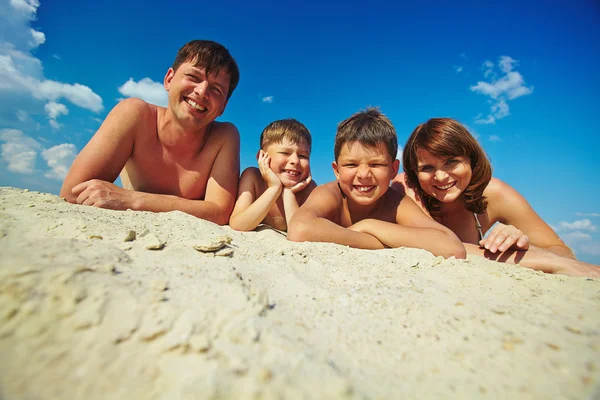 Familie liggend op zandstrand — Stockfoto