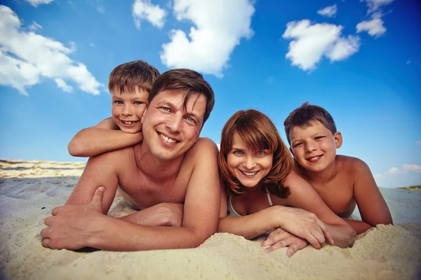Para i rodzeństwo leżące na piasku — Zdjęcie stockowe