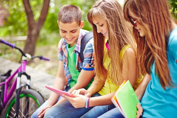 Moderne Teenager schmökern im Park — Stockfoto