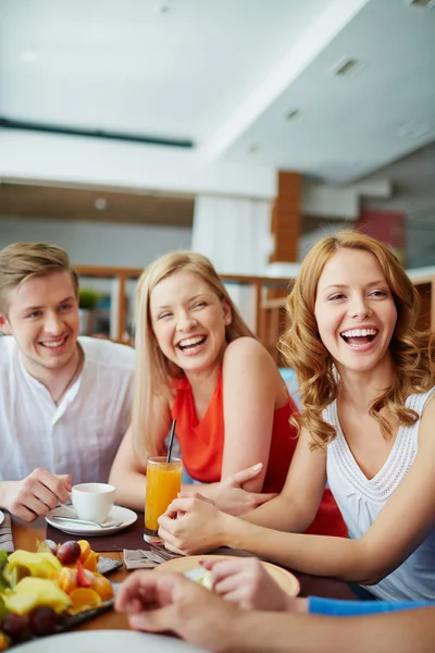 Meninas e cara fazendo lanche no café — Fotografia de Stock