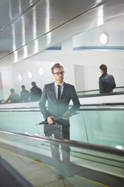 evrak çantası ve yürüyen merdiven şemsiyesi ile işadamı