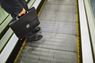 yürüyen merdiven azalan evrak çantası ile işadamı