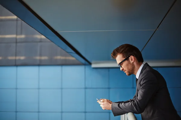 Empresario con lectura de teléfonos celulares sms — Foto de Stock