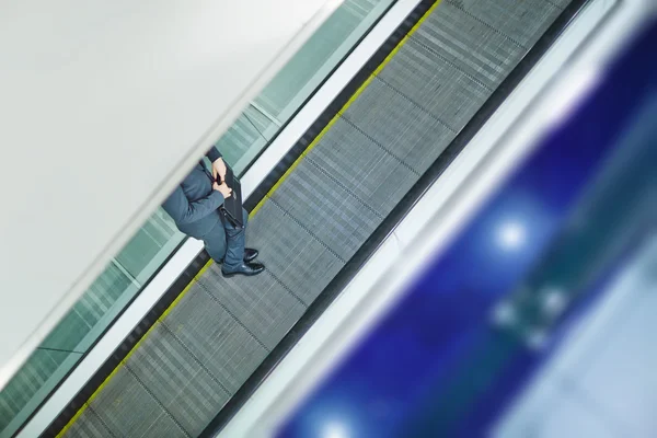 Geschäftsmann stürzt mit Aktentasche auf Rolltreppe — Stockfoto