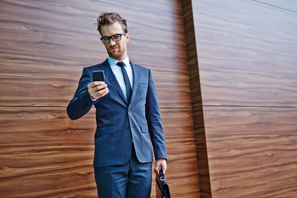 Geschäftsmann mit Aktentasche und Handy — Stockfoto