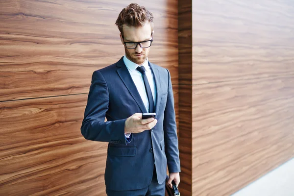 Zakenman in pak met behulp van mobiele telefoon — Stockfoto