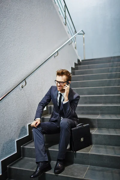 Empresário falando ao telefone nas escadas — Fotografia de Stock