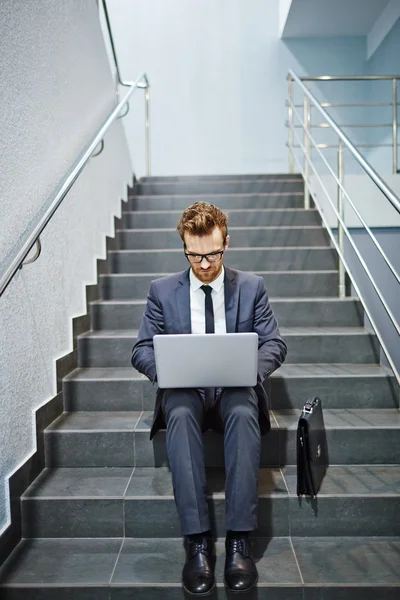 Affärsman arbetar med laptop på trappan — Stockfoto