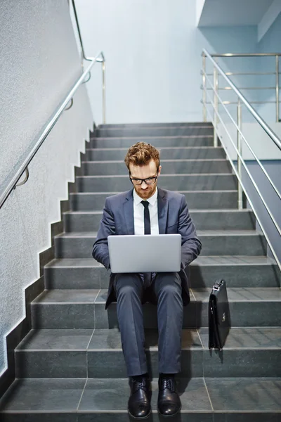 Homme d'affaires travaillant avec ordinateur portable dans les escaliers — Photo