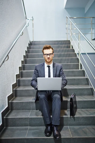 Homme d'affaires travaillant avec ordinateur portable dans les escaliers — Photo