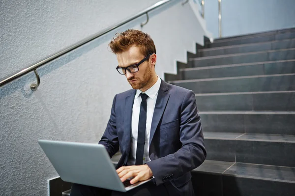 Homme d'affaires travaillant avec ordinateur portable dans les escaliers — Photo