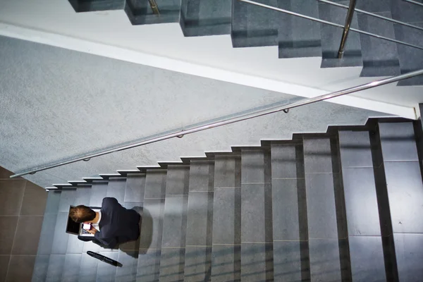 Homme d'affaires travaillant dans les escaliers — Photo