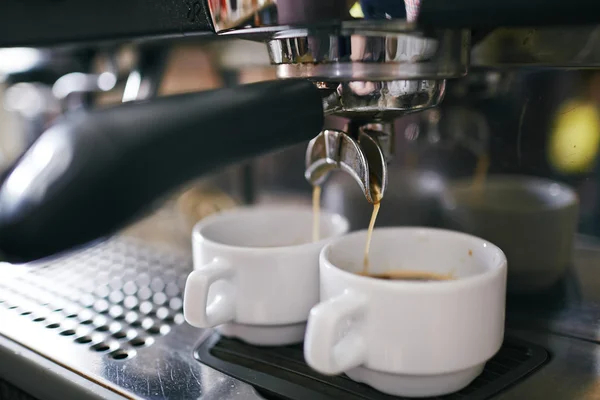 Café vertiendo en tazas en la máquina de café —  Fotos de Stock