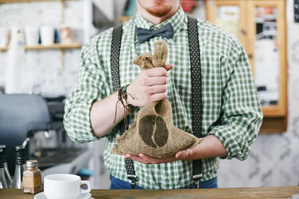 Barista holding säck med kaffe korn — Stockfoto