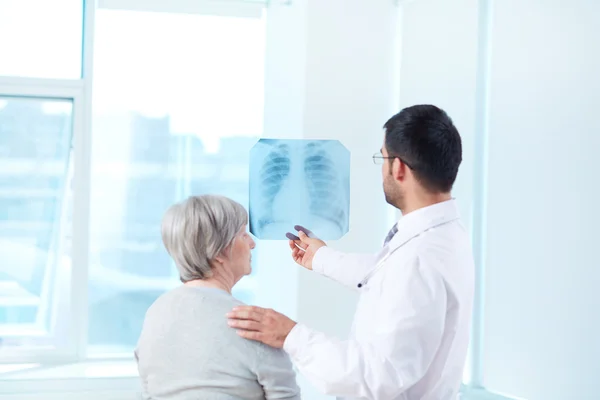 Doctor mostrando rayos X al paciente — Foto de Stock