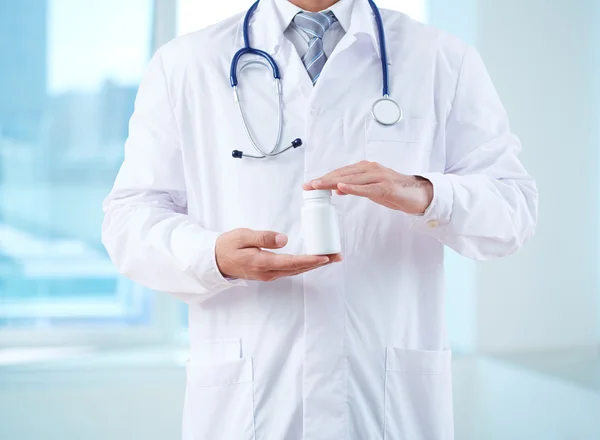 Doctor in uniform holding vitamins — Stock Photo, Image