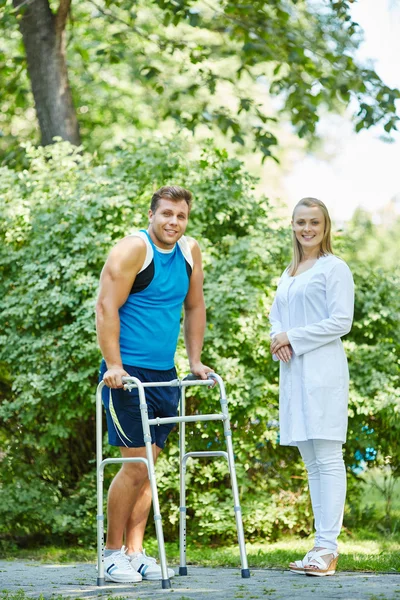Infermiera in uniforme e paziente con walker — Foto Stock