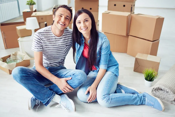 Couple of settlers sitting on the floor — Stock Photo, Image