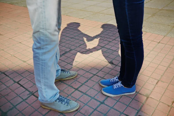 Para stojący na chodniku z ich cienie — Zdjęcie stockowe
