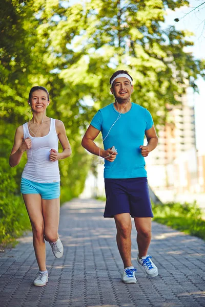 Man and woman running in park — Stock Photo, Image